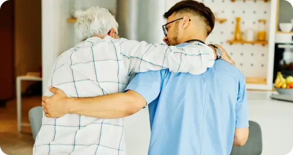 Imagen de auxiliar de Servicios Globales Kelly ayudando a un anciano a caminar